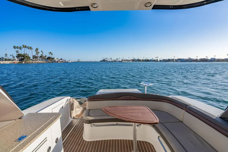 Slide: The Image of 2016 Sea Ray 370 Express Cruiser with scenic ocean view and luxurious seating area. - 18