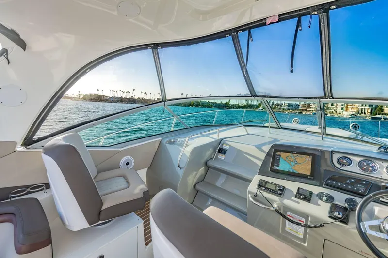 Slide: The Image of 2016 Sea Ray 370 Express Cruiser helm with navigation system, overlooking scenic waterfront. - 20