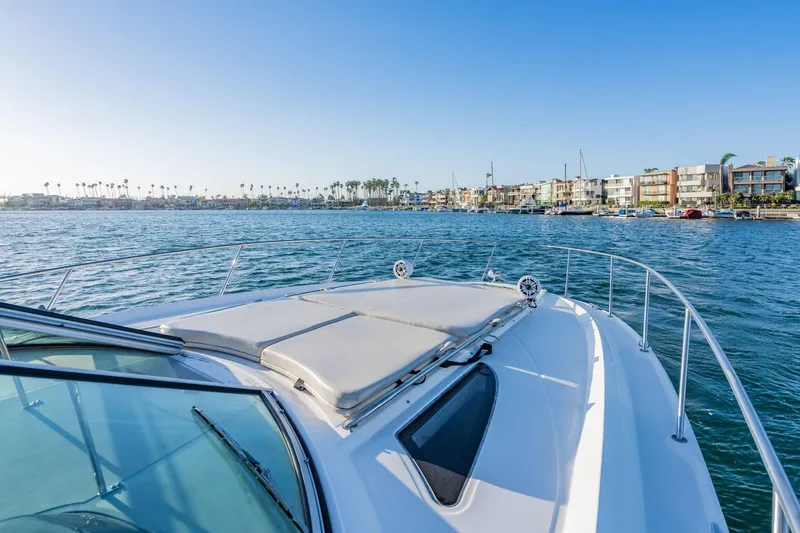 Slide: The Image of 2016 Sea Ray 370 Express Cruiser on calm waters near coastal homes. - 28