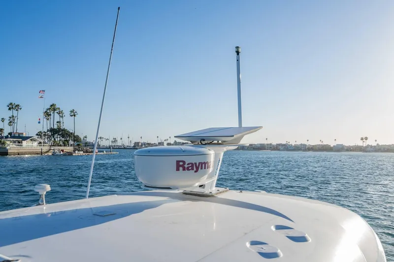 Slide: The Image of 2016 Sea Ray 370 Express Cruiser on water, featuring Raymarine radar, coastal view. - 32