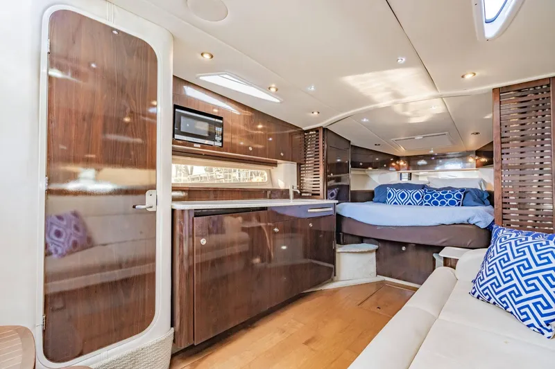 Slide: The Image of Luxurious interior of 2016 Sea Ray 370 Express Cruiser with modern kitchen and cozy sleeping area. - 37