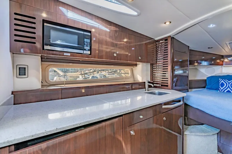 Slide: The Image of Luxurious interior of 2016 Sea Ray 370 Express Cruiser with modern kitchen and cozy sleeping area. - 41