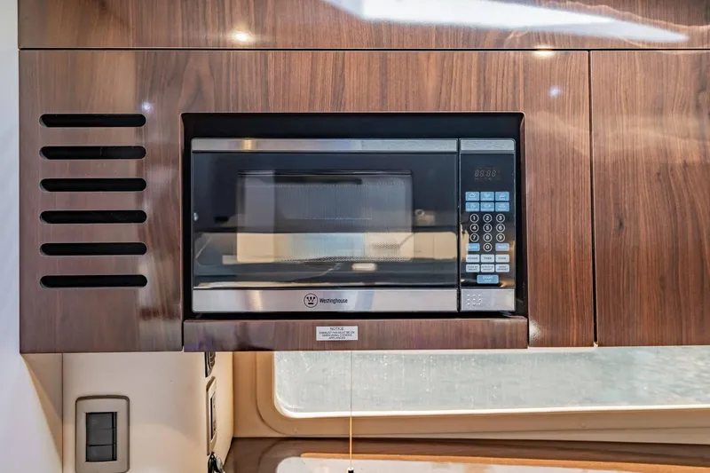 Slide: The Image of Built-in microwave in 2016 Sea Ray 370 Express Cruiser's wooden cabinetry. - 51