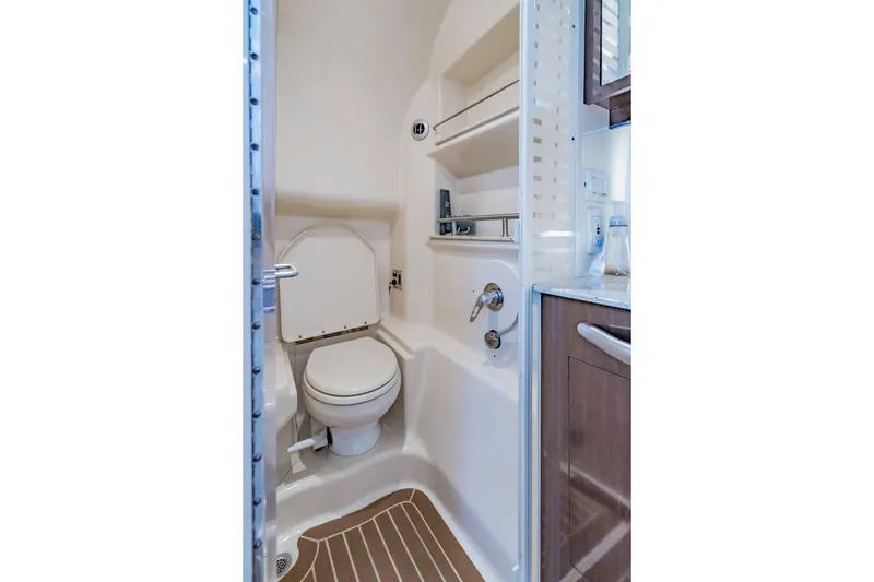 Slide: The Image of Compact bathroom in 2016 Sea Ray 370 Express Cruiser with toilet and shelving. - 57