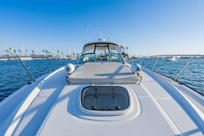 Slide: The Image of 2016 Sea Ray 370 Express Cruiser on calm waters, clear sky, marina in background. - 31