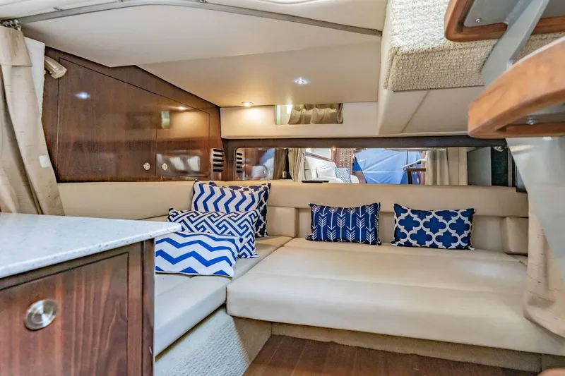 Slide: The Image of Interior of 2016 Sea Ray 370 Express Cruiser with patterned cushions and wood accents. - 48