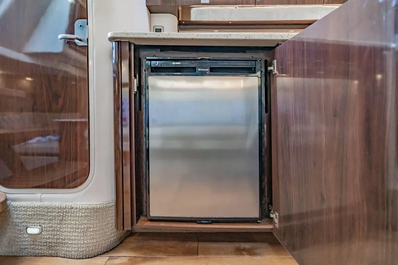 Slide: The Image of Compact refrigerator in 2016 Sea Ray 370 Express Cruiser's wooden interior. - 50
