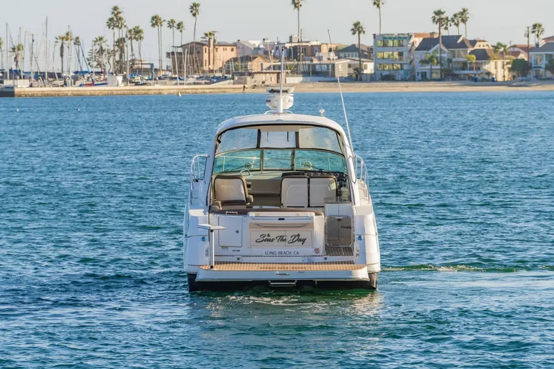 Slide: The Image of 2016 Sea Ray 370 Express Cruiser on water near coastal cityscape. - 8