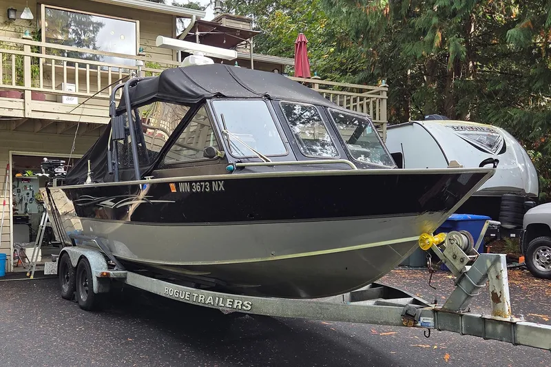 The Image of 2008 Alumaweld 22 Intruder boat on trailer, parked in driveway near house and trees. - 0