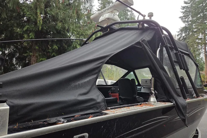 Slide: The Image of 2008 Alumaweld 22 Intruder boat with black canopy, parked outdoors. - 4