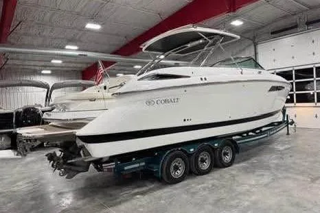 Slide: The Image of 2016 Cobalt 336 boat in a showroom, on a trailer, with a sleek white design. - 24