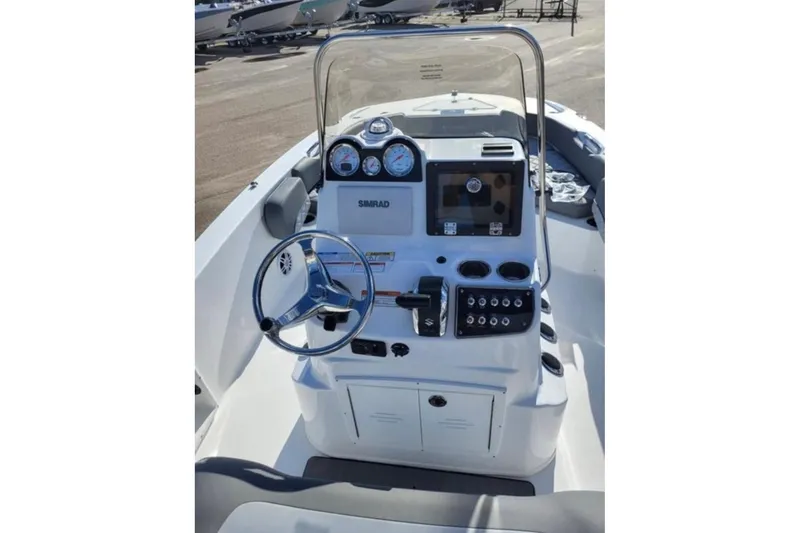 Slide: The Image of 2025 NauticStar 191 Hybrid boat dashboard with steering wheel and control panel. - 10