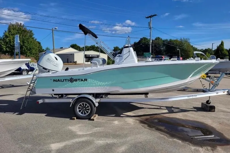 Slide: The Image of 2025 NauticStar 191 Hybrid boat on trailer, featuring a sleek design and Suzuki outboard motor. - 4