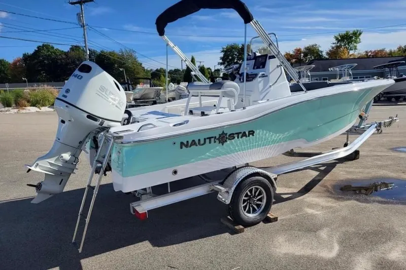 Slide: The Image of 2025 NauticStar 191 Hybrid boat on trailer, featuring sleek design and powerful outboard motor. - 6