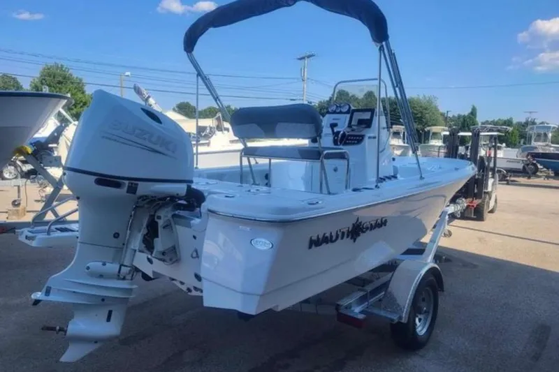 Slide: The Image of 2024 NauticStar 194 Bay boat with Suzuki engine on trailer, outdoor setting. - 2