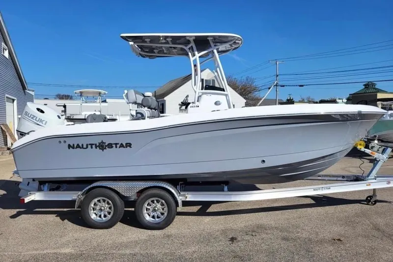 The Image of 2025 NauticStar 222 Offshore boat on trailer, side view, clear sky background. - 1