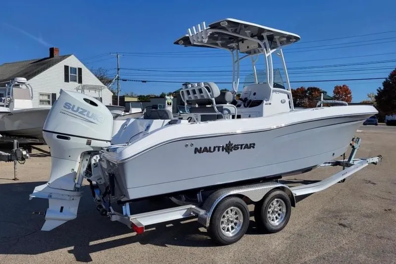 Slide: The Image of 2025 NauticStar 222 Offshore boat on trailer with Suzuki outboard motor. - 2