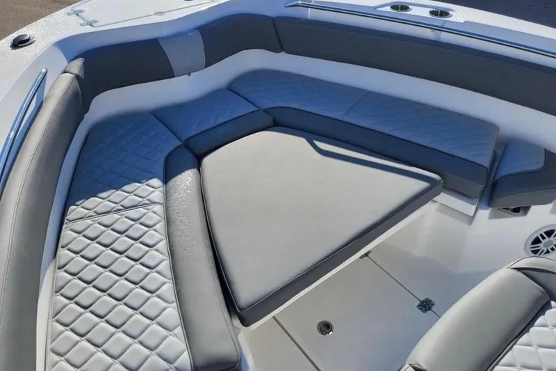 Slide: The Image of 2025 NauticStar 222 Offshore boat interior with cushioned seating and diamond-pattern upholstery. - 6