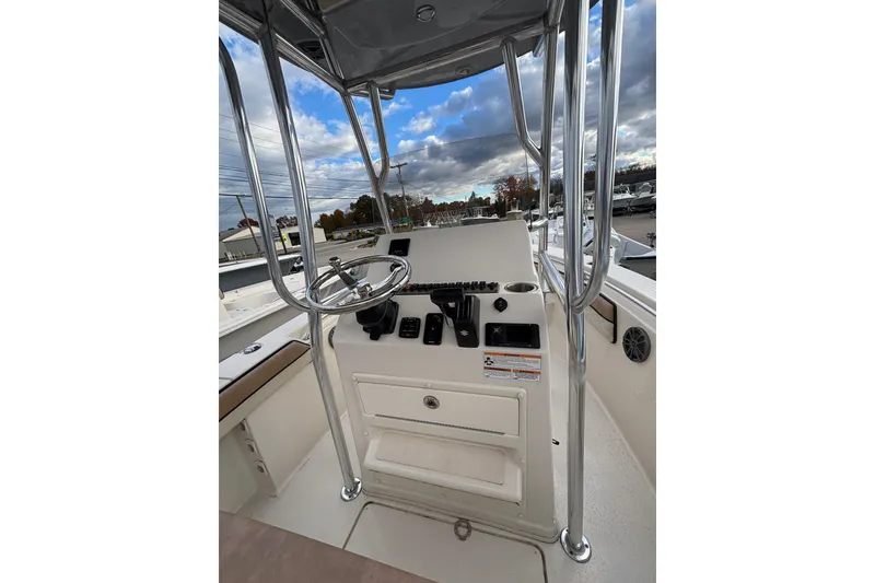Slide: The Image of 2023 Sea Chaser 20 HFC boat console with steering wheel and controls under cloudy sky. - 5
