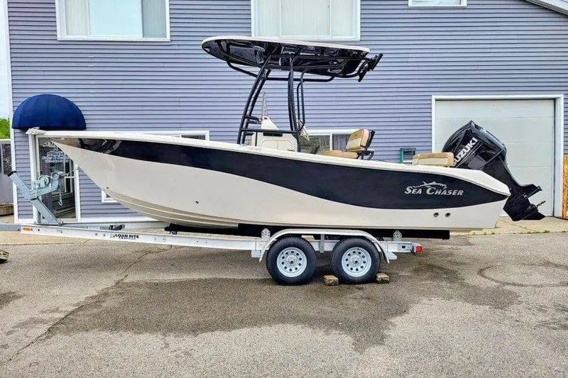 The Image of 2023 Sea Chaser 22 HFC boat on trailer, parked outside a building. - 1