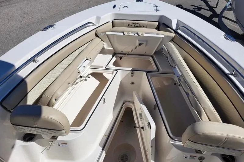 Slide: The Image of 2023 Sea Chaser 22 HFC boat interior with open storage compartments and cushioned seating. - 6