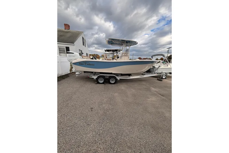 The Image of 2023 Sea Chaser 24 HFC boat on trailer, parked outdoors under cloudy sky. - 1