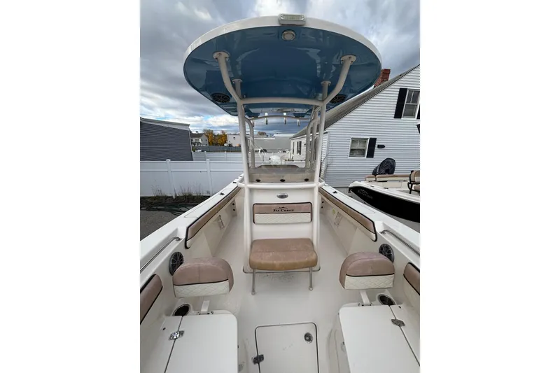 Slide: The Image of 2023 Sea Chaser 24 HFC boat interior with seating and console under a blue canopy. - 11