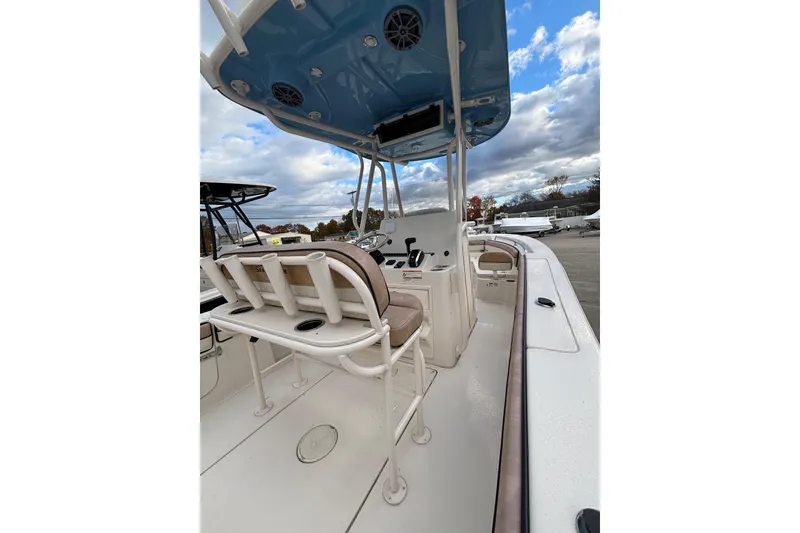 Slide: The Image of 2023 Sea Chaser 24 HFC boat interior with seating and control panel under blue canopy. - 6