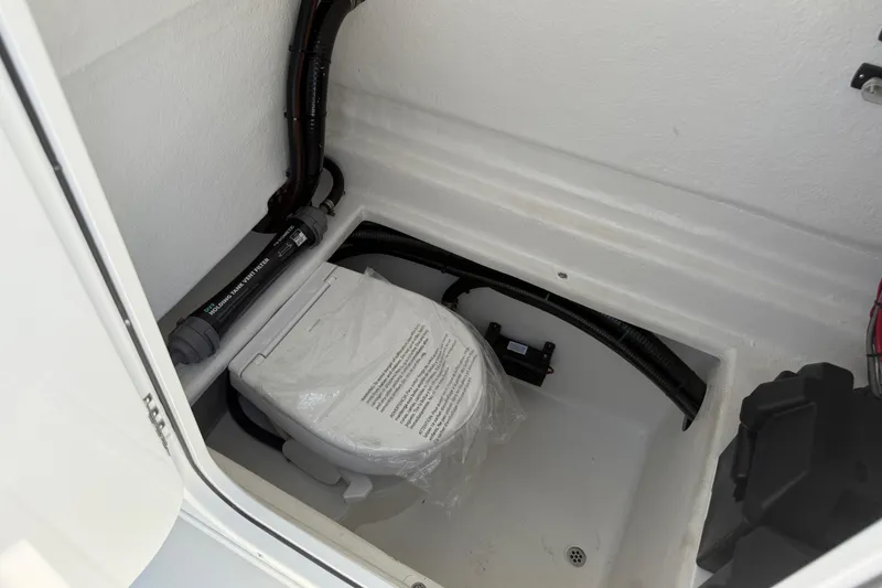Slide: The Image of Interior of 2025 Pair Customs 28 Center Console boat, featuring a compact marine toilet. - 10