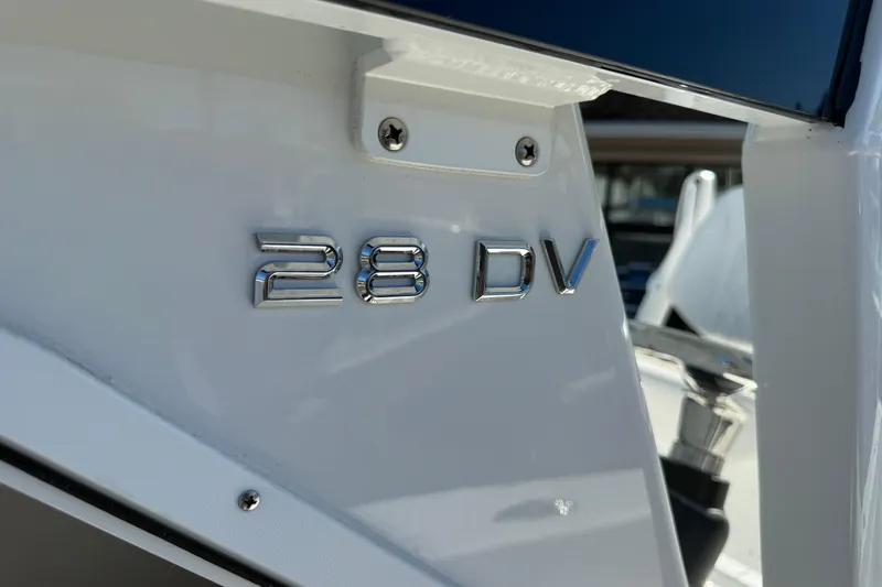Slide: The Image of 2025 Pair Customs 28 Center Console boat with "28 DV" emblem detail. - 12