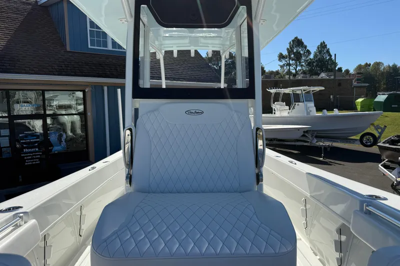 Slide: The Image of 2025 Pair Customs 28 Center Console boat with white quilted seating, docked outdoors. - 18