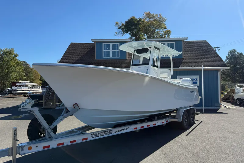 Slide: The Image of 2025 Pair Customs 28 Center Console boat on trailer, parked outside a blue building. - 23