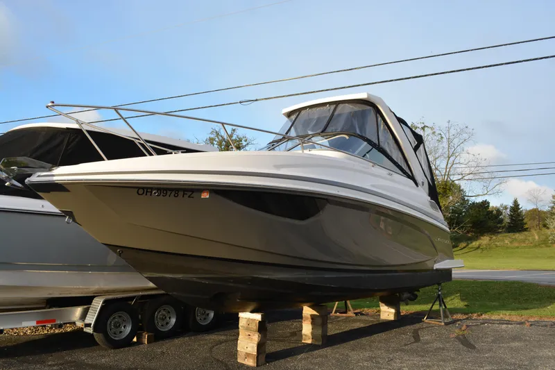 The Image of 2016 Regal 28 Express boat on blocks, parked outdoors. - 0