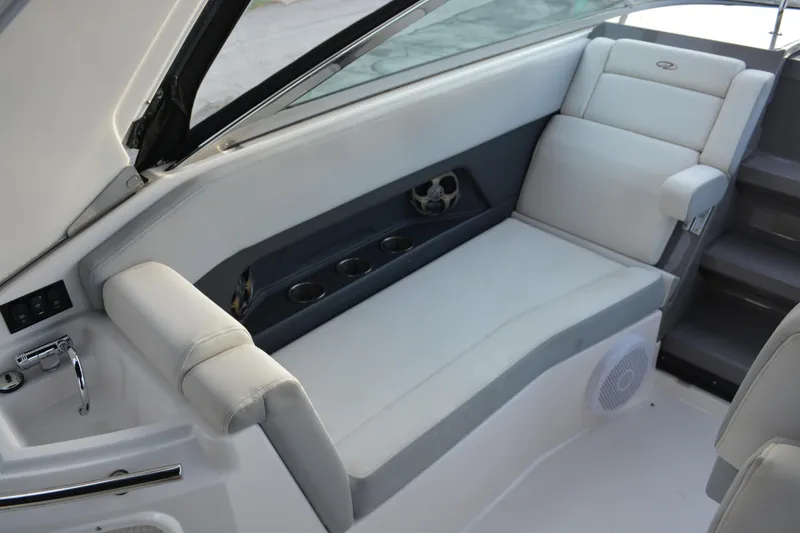 Slide: The Image of 2016 Regal 28 Express boat interior with white seating and cup holders. - 11