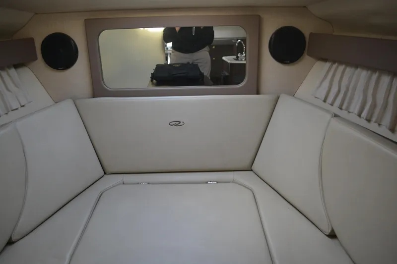Slide: The Image of Interior cabin of 2016 Regal 28 Express boat with beige seating and window. - 15