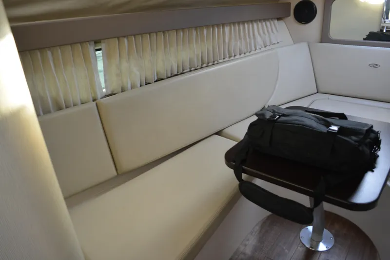 Slide: The Image of Interior of 2016 Regal 28 Express boat with beige seating and a small table. - 16