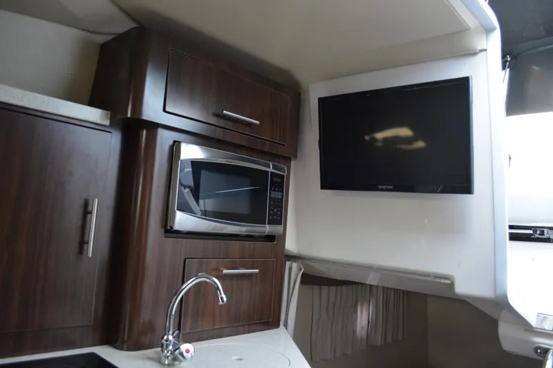 Slide: The Image of 2016 Regal 28 Express interior with microwave, TV, and modern cabinetry. - 22