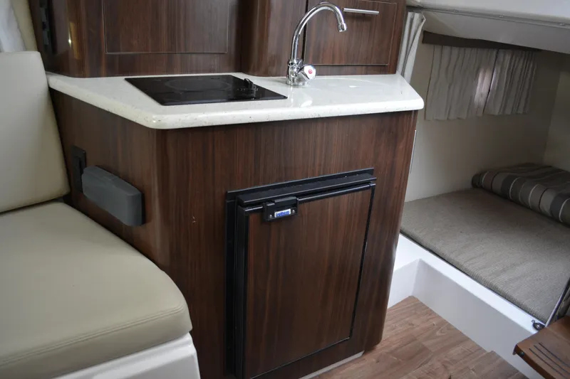 Slide: The Image of 2016 Regal 28 Express boat interior with kitchenette and seating area. - 23
