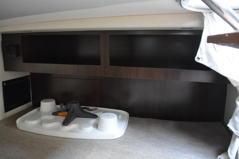 Slide: The Image of 2016 Regal 28 Express cabin interior with dark wood paneling and storage space. - 25