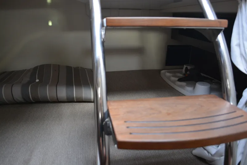 Slide: The Image of Interior cabin of 2016 Regal 28 Express boat with ladder and striped bedding. - 26