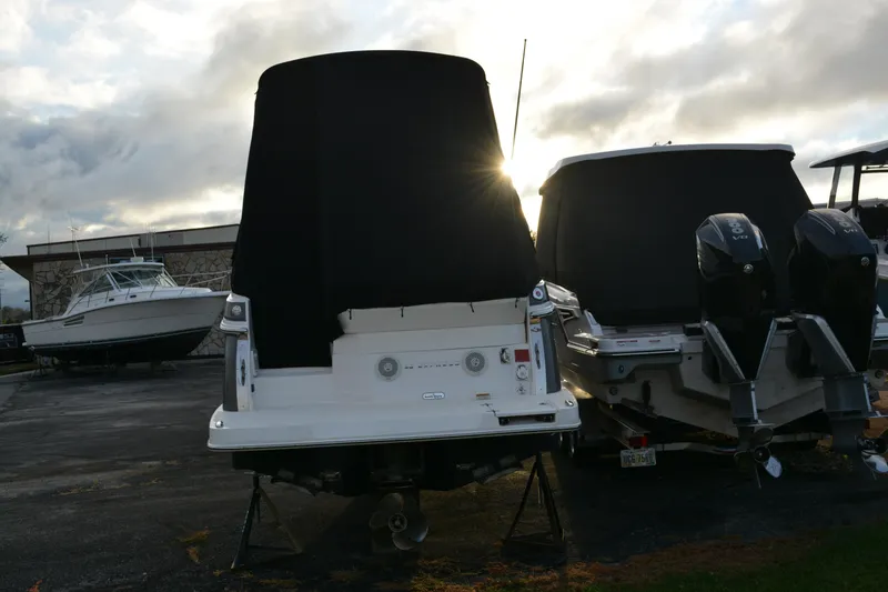 Slide: The Image of 2016 Regal 28 Express boat covered, parked alongside other boats at sunset. - 3