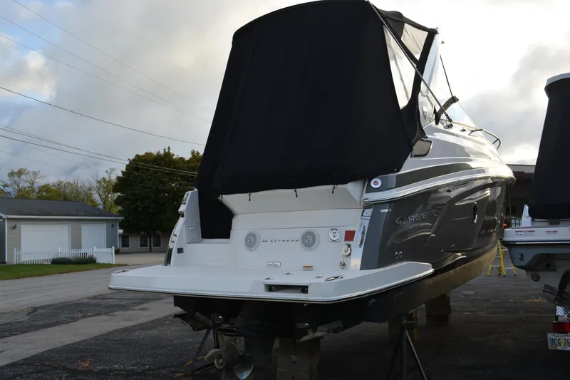 Slide: The Image of 2016 Regal 28 Express boat with black cover, parked on a street. - 4