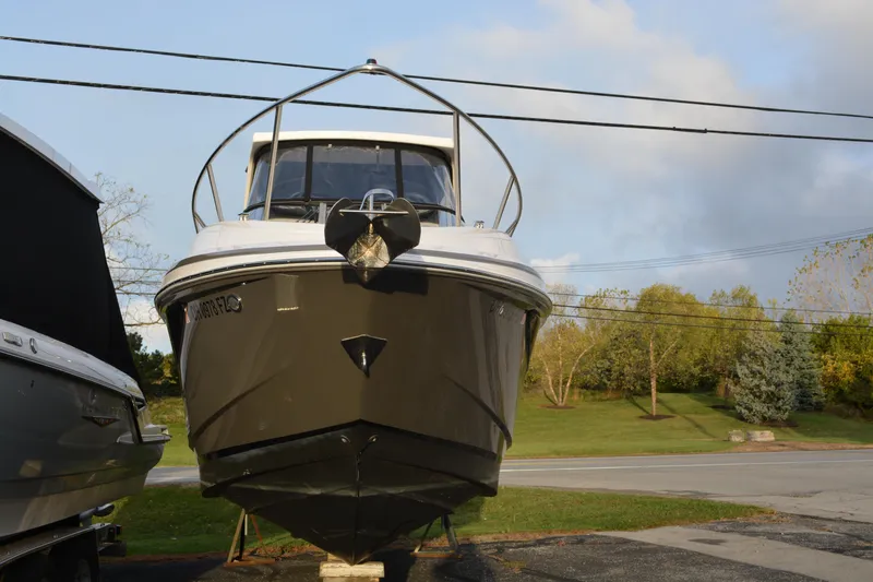 Slide: The Image of 2016 Regal 28 Express boat on display, front view with trees in the background. - 6
