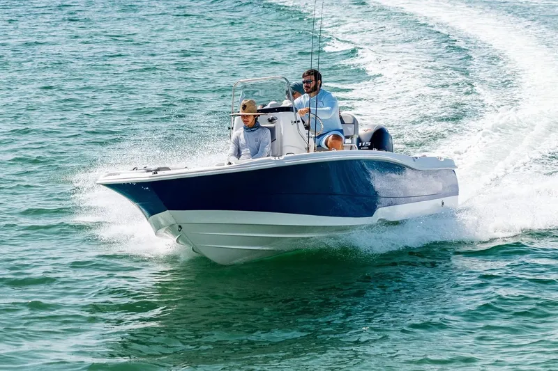 The Image of 2025 NauticStar 191 Hybrid boat cruising on open water, two people onboard. - 1
