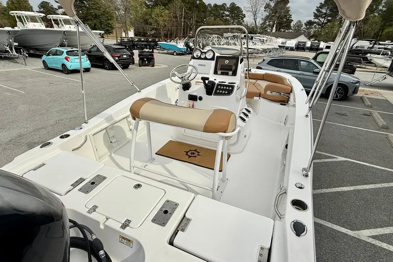 Slide: The Image of 2025 NauticStar 191 Hybrid boat interior with beige seating in a parking lot. - 21