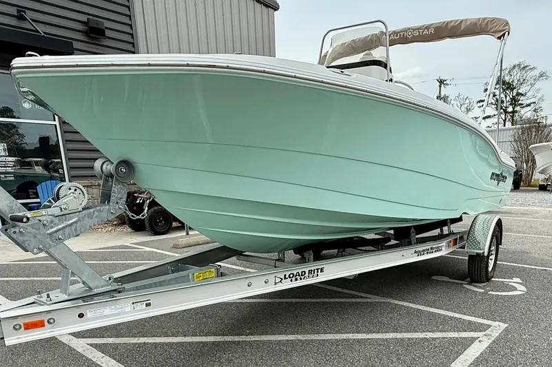 Slide: The Image of 2025 NauticStar 191 Hybrid boat on trailer, mint green hull, parked outdoors. - 7