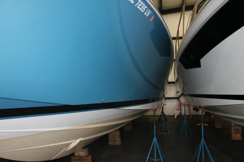 Slide: The Image of 2022 Tiara Yachts 43 LS in storage, blue hull, supported by stands. - 2