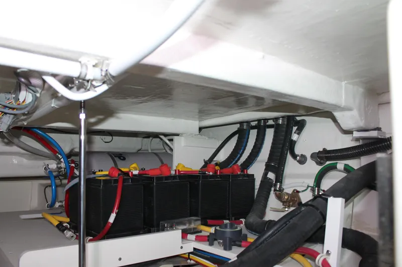 Slide: The Image of Engine compartment of 2022 Tiara Yachts 43 LS, featuring batteries and wiring. - 70
