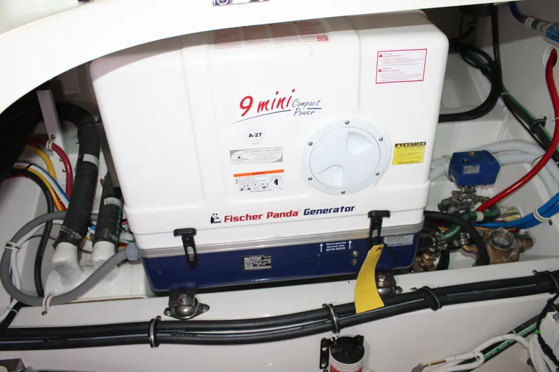 Slide: The Image of Fischer Panda generator in 2022 Tiara Yachts 43 LS engine room, surrounded by wiring and components. - 76