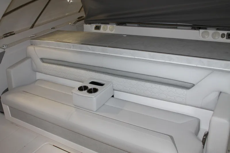 Slide: The Image of 2022 Tiara Yachts 43 LS interior seating with cup holders, featuring elegant white upholstery. - 8